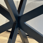 Close-up van de zwarte stalen poot van de travertin eettafel