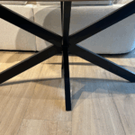 Volledig beeld van de travertin tafel met zwarte stalen poot